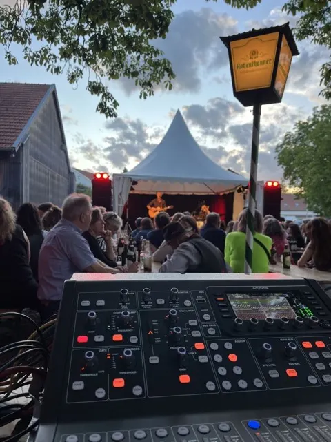 Biergarten-Bühne am Abend mit Mischpult im Vordergrund
